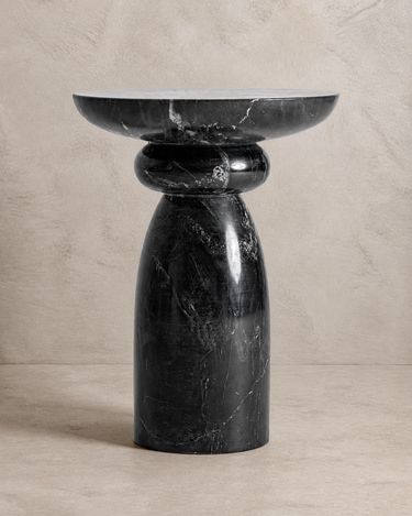 Mesa auxiliar de mármol negro de Vical ante pared texturizada topo claro
