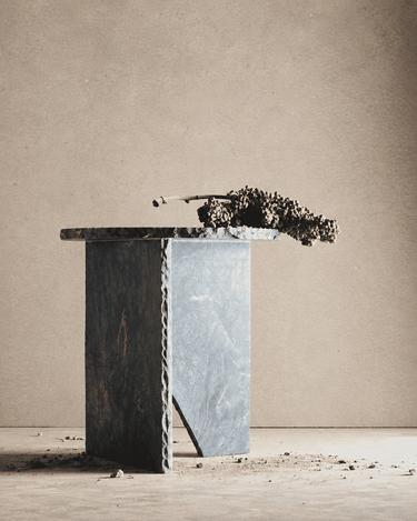 Mesa de mármol verde con una rama seca sobre el tablero