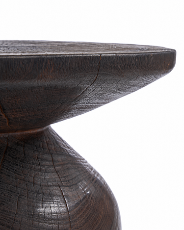 Mesa auxiliar redonda de madera oscura, detalle del borde del tablero y su unión con el pie