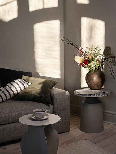 Mesa auxiliar de terrazo iluminada por el sol en un salón