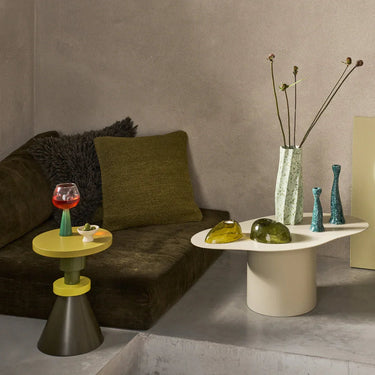 Mesa de centro de hierro almendra: junto a un sofá con textiles verdes