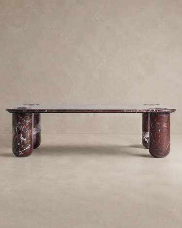 Mesa de centro de mármol burdeos brillante de Vical ante pared texturizada topo claro
