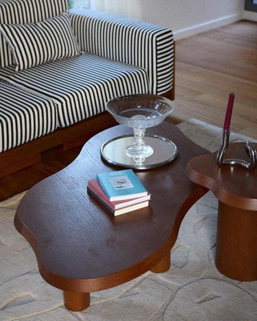 Mesa de centro de roble con acabado nogal de Gabrielle Paris frente a un sofá de rayas
