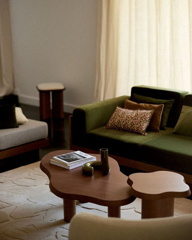 Mesa de centro Gabrielle Paris de forma orgánica junto a una mesa auxiliar