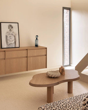 Mesa de centro de roble natural de Gabrielle Paris con contorno curvo, en un salón