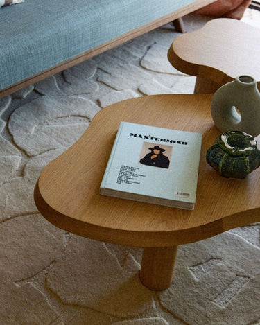 Detalle del contorno curvo del tablero de roble con un libro y objetos decorativos