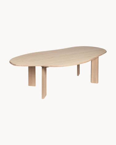 Mesa de Ferm Living: vista diagonal del tablero orgánico y las patas planas.