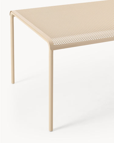Detalle del borde del tablero perforado y una pata beige.