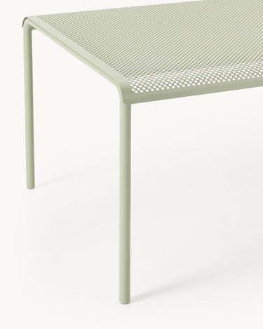 Detalle del canto perforado del tablero y una pata verde.