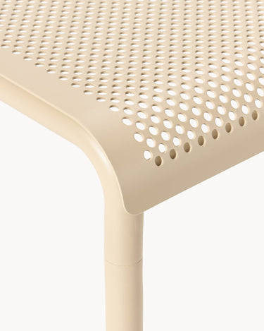 Macro de las perforaciones circulares del tablero beige.