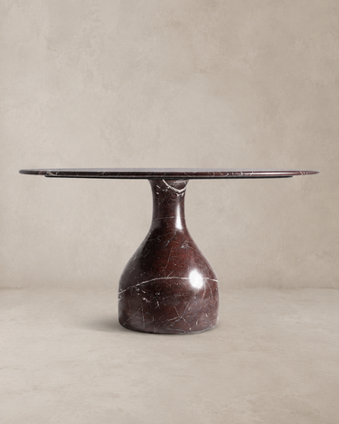 Mesa de comedor de mármol burdeos brillo de Vical ante pared texturizada topo claro