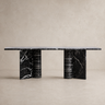Mesa de comedor de mármol negro de Vical ante pared texturizada topo claro