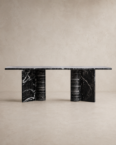Mesa de comedor de mármol negro de Vical ante pared texturizada topo claro