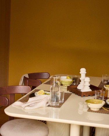 Mesa de comedor Gabrielle Paris: detalle del tablero crema con vasos y cuencos