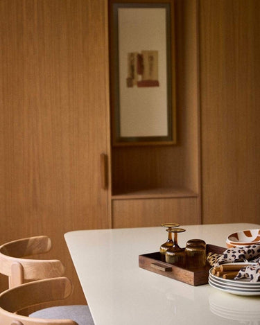 Mesa de comedor lacada crema junto a mobiliario de madera