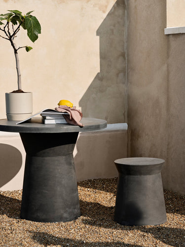 Mesa de comedor compacta antracita junto a un sofá gris