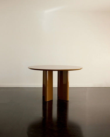Mesa de comedor redonda lacada caramelo vista de frente, con el tablero despejado