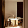 Mesa de comedor redonda lacada en crema de Gabrielle Paris junto a una ventana