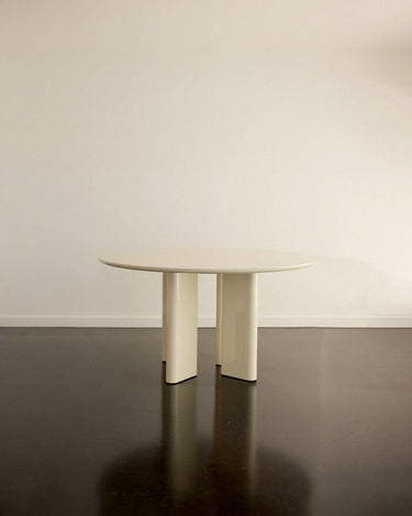 Silueta de las mesas de comedor redondas lacadas crema Gabrielle Paris sobre un suelo oscuro