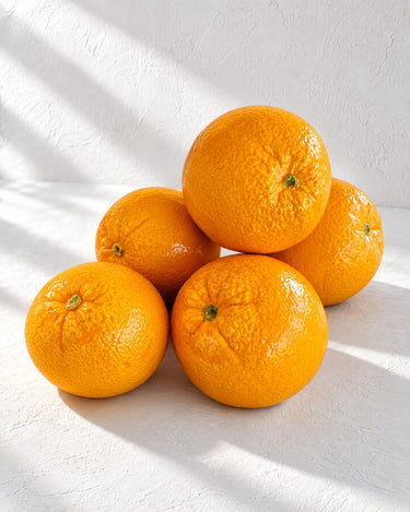 Naranjas de cerámica de Ánfora vistas desde arriba sobre cal blanca