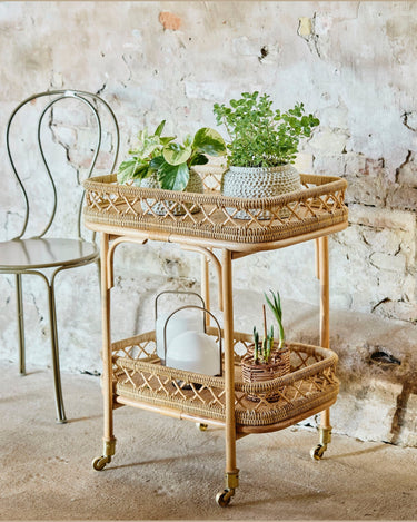Mesa auxiliar de ratán natural con ruedas Nordal en ambiente de salón