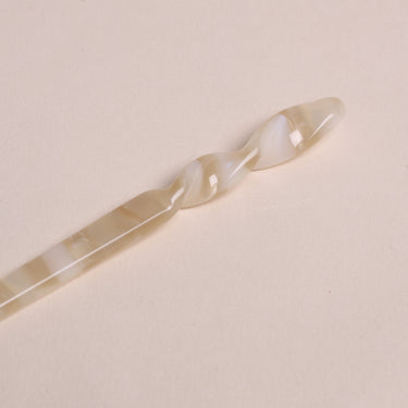 Palillos para el pelo de acetato crema y caramelo de Peignée Paris: detalle del extremo de una pieza.