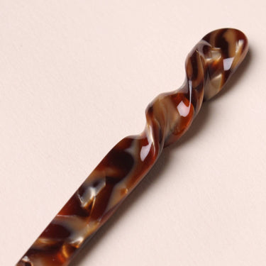 Palillos para el pelo de acetato marrón efecto carey de Peignée Paris: detalle de la torsión de una pieza.