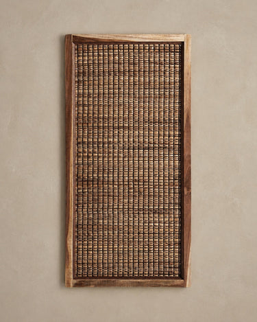 Panel Vical pequeño de fibra natural marrón sobre pared topo clara texturizada