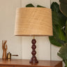 Pantalla de rafia natural cónica grande de Mahe Homeware, con ribete crema en un ambiente con madera y plantas.