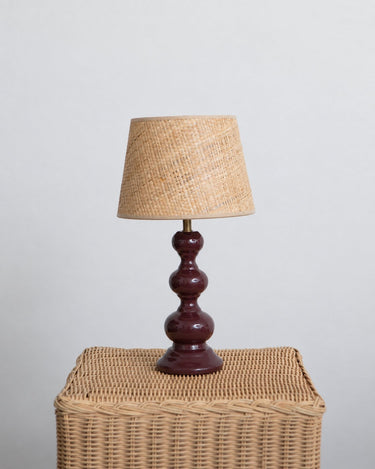 Pantalla de lámpara de Mahe Homeware sobre una base de cerámica burdeos.