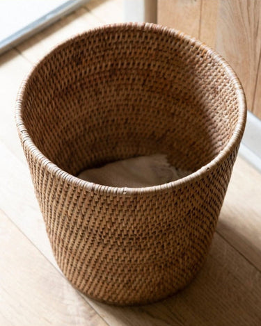 Papelera redonda de ratán natural en el baño