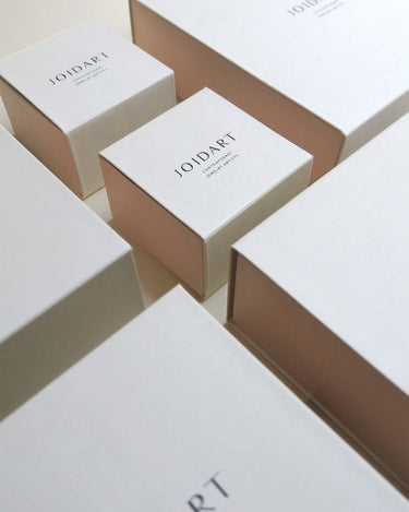 Varias cajas blancas cerradas con marca Joidart, sin joyas visibles.