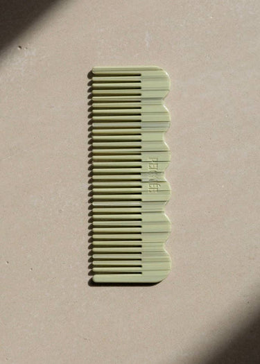 Peines de acetato verde salvia de Peignée Paris: una pieza sobre una superficie clara con luz natural.