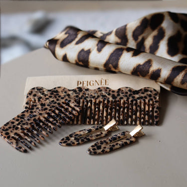 Peine de viaje de acetato con estampado de leopardo de Peignée Paris, junto a otros accesorios con estampado de leopardo.