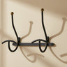 Perchero de pared vintage de metal negro con detalles dorados en formato vertical
