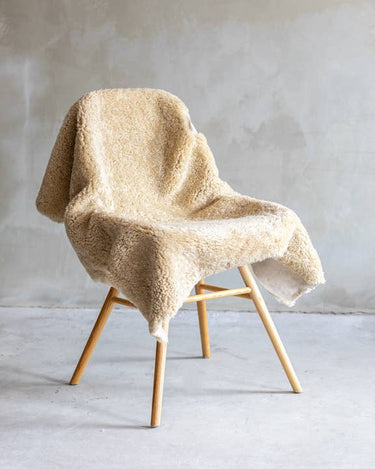 Piel de oveja Crossbreed beige, colocada sobre un sillón