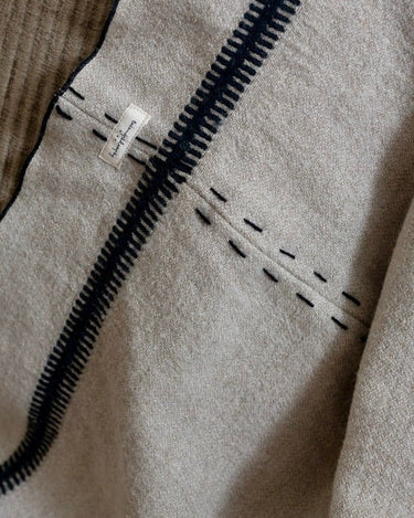 Plaid beige de lino y lana de Bed and Philosophy, detalle del tejido y las líneas negras