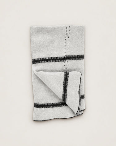 Plaid beige de lino y lana, plegado con el ribete oscuro visible