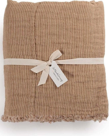 Plaid Okapi Bruxelles de lino gofrado reversible en topo y beige de Le Monde Sauvage, plegado y atado con cinta