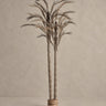Planta artificial Vical de fibra natural en tonos neutros sobre pared y suelo topo claro texturizado