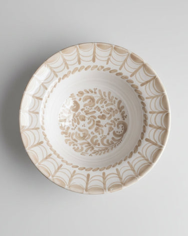 Plato de Leandro Cano: plato hondo cenital con arcos beige en el borde y centro decorado.