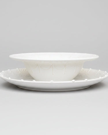 Plato de Leandro Cano: perfil de plato hondo blanco colocado sobre plato llano.