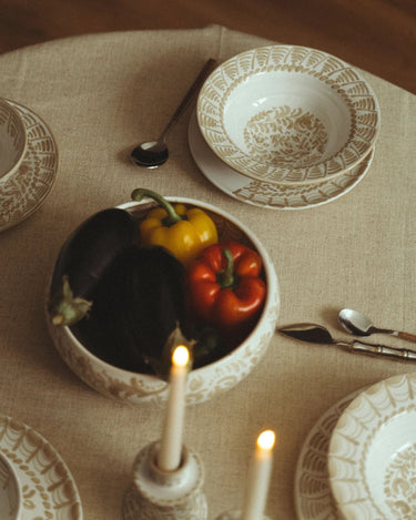 Plato de Leandro Cano: mesa vista desde arriba con plato hondo, cuenco con hortalizas y cubiertos.