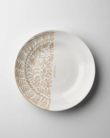 Plato de Leandro Cano: plato de postre cenital: una mitad decorada en beige y otra blanca.