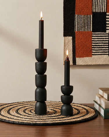 Portavelas de Madera Tallada a Mano negros, dos portavelas negros de distintas alturas con velas encendidas