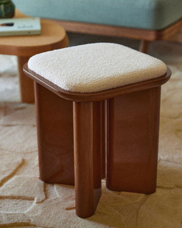 Puf de Gabrielle Paris, silueta y acabado de puf de madera lacada caramelo