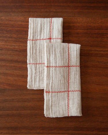 Detalle del tejido natural con cuadros y ramas rojas