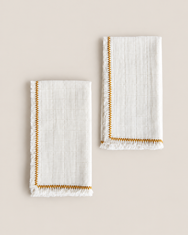 Servilletas de algodón natural con zigzag mostaza sobre fondo topo claro