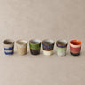 Seis tazas de café 70s Ceramics sobre fondo crema