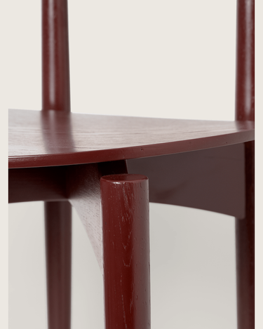Detalle de las uniones de madera bajo el asiento de una de las sillas Herman de fresno marrón rojizo.
